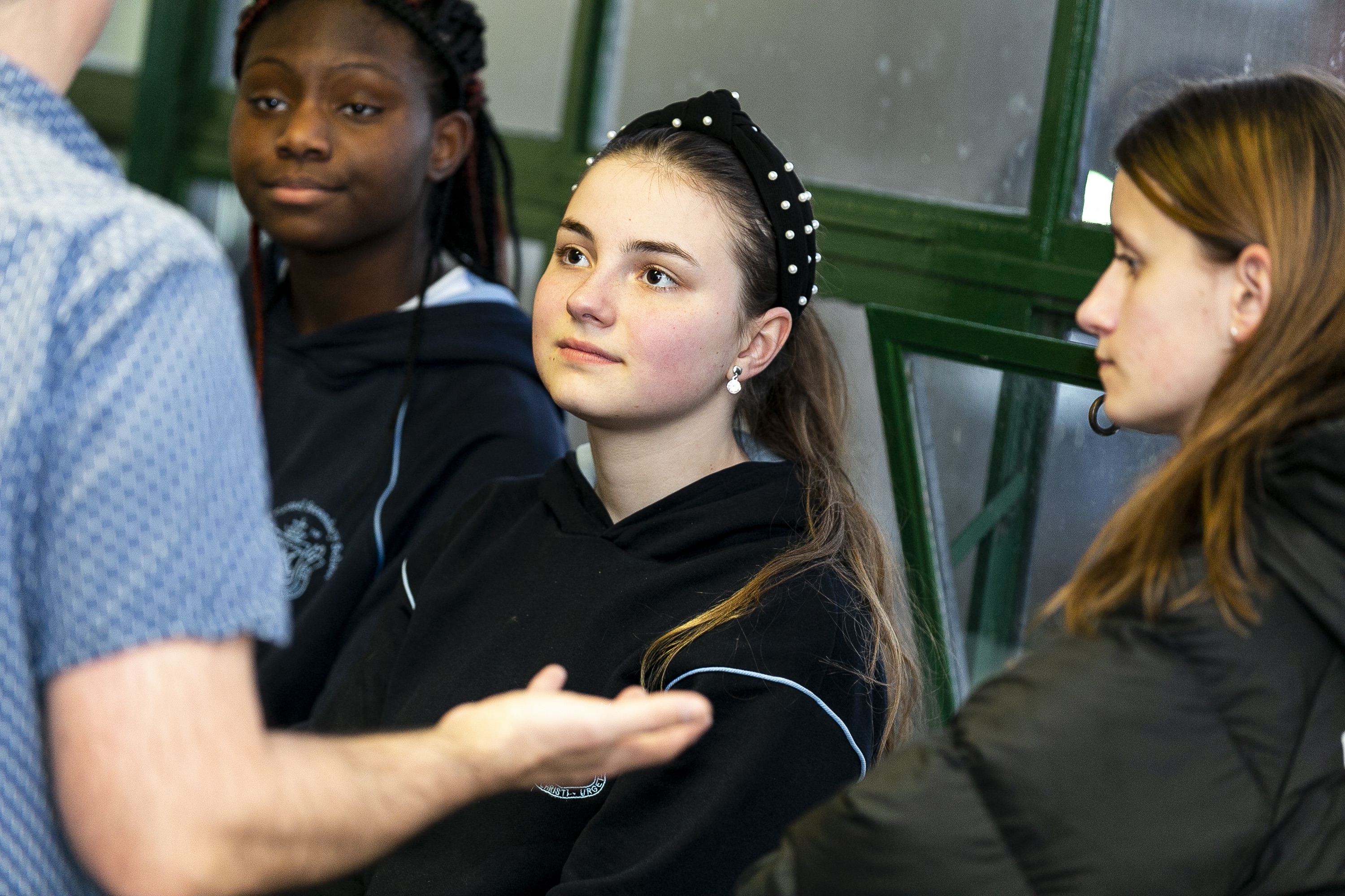 girls listening to adult speaking