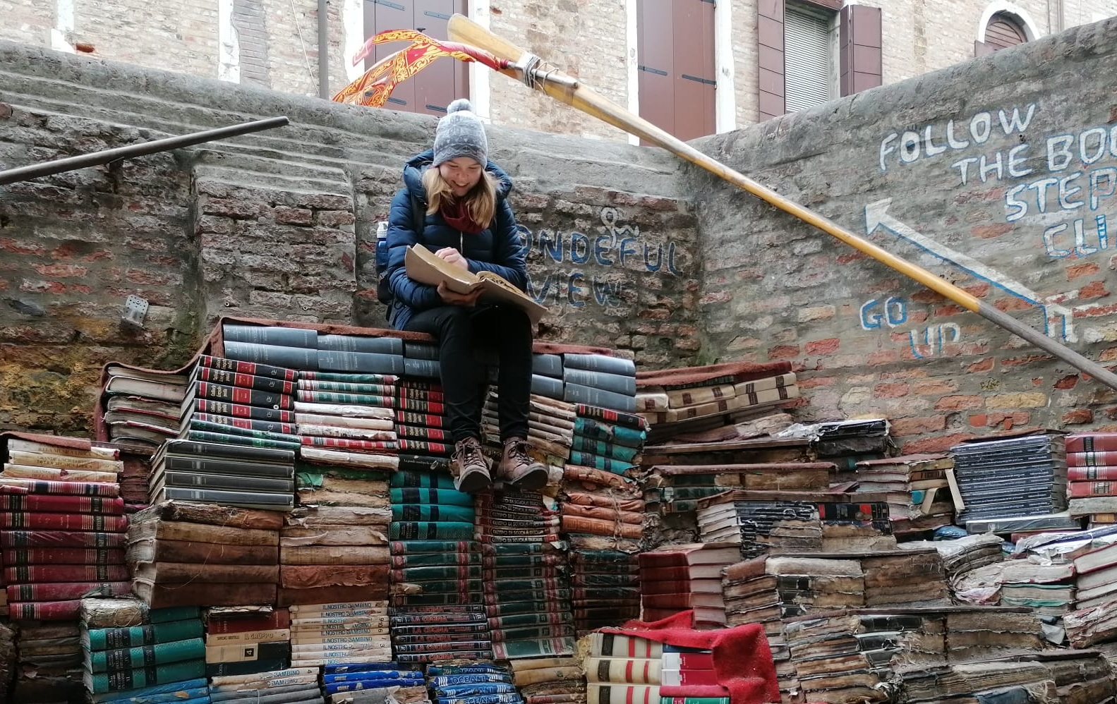 Emma sitting on a pile of books