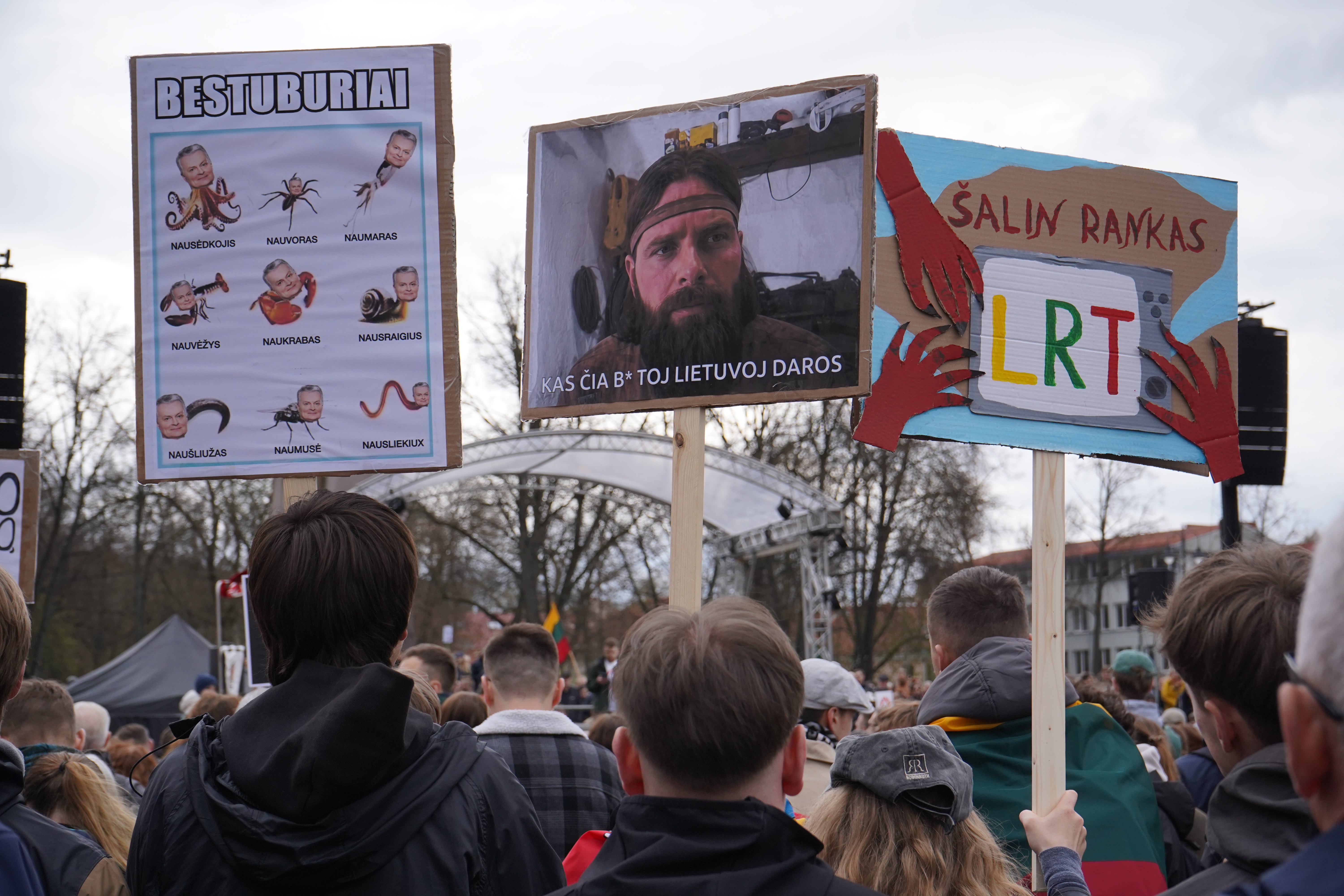 First sign depicts president Gitanas Nausėda as various invertebrates The second says "What the f*ck is happening in Lithuania“ The third one says "Hands off LRT"