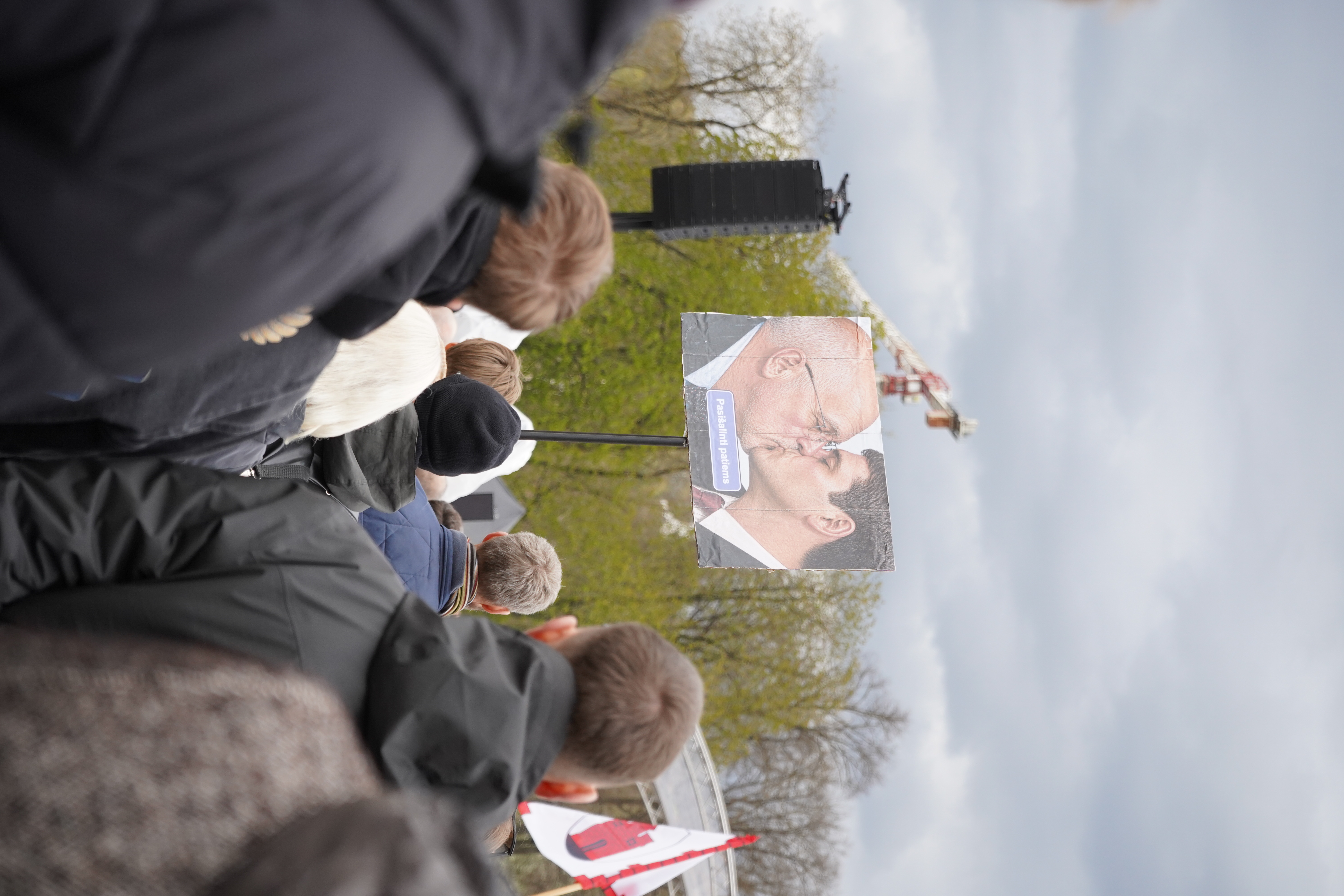 The sign shows Remigijus Žemaitaitis kissing Juozas Olekas