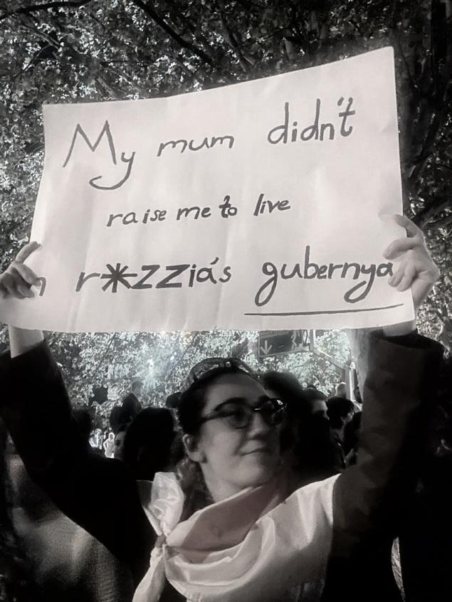A young woman holding a sign in a protest