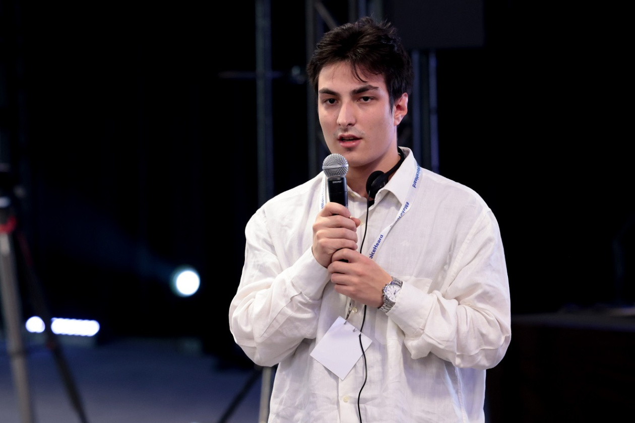 A young person holding the microphone and speaking