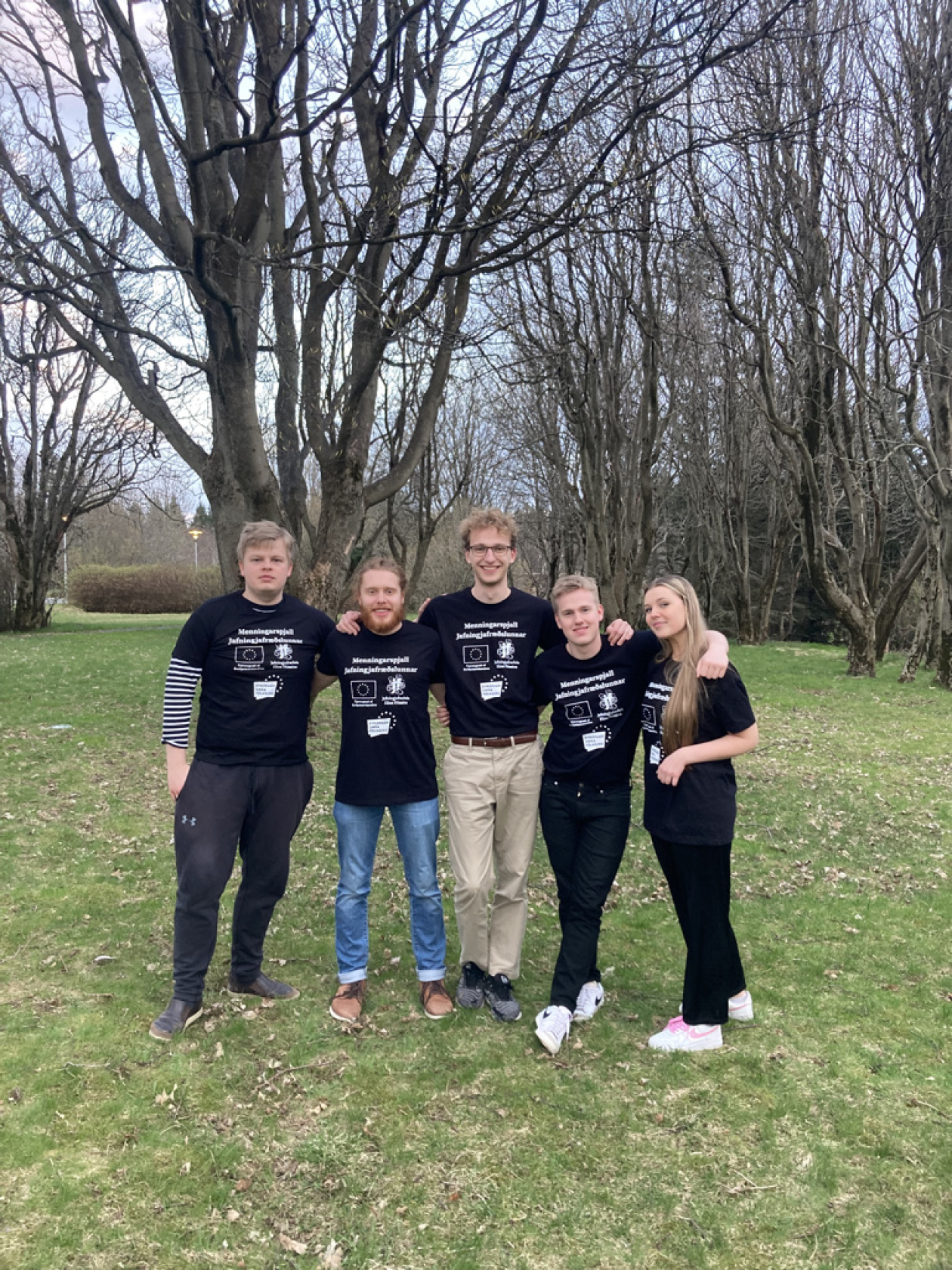 Group of 5 peer-to-peer workers in iceland standing in front of a tree