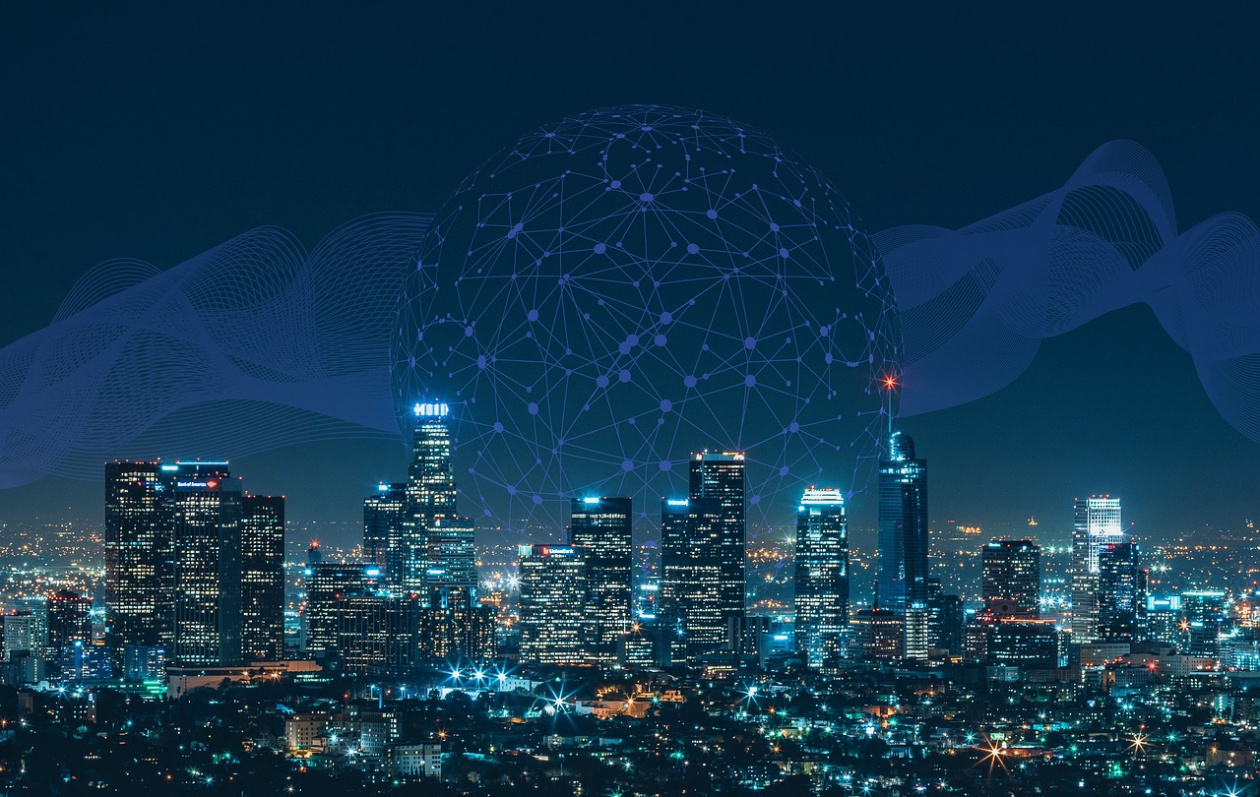 Night city skyline with lit skyscrapers and a digital network globe overlay, symbolising global connectivity and technology.