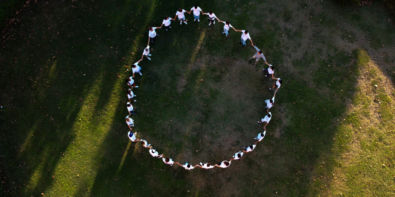 Young people giving hands and making a big circle