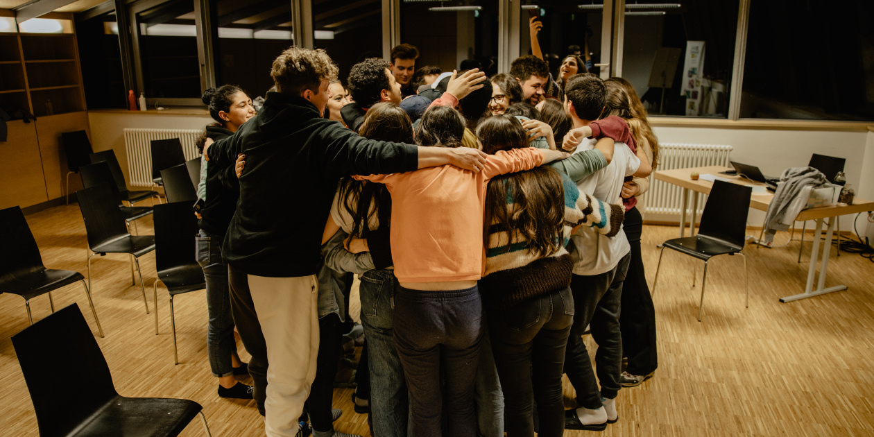 Young people embracing each other in one group hug