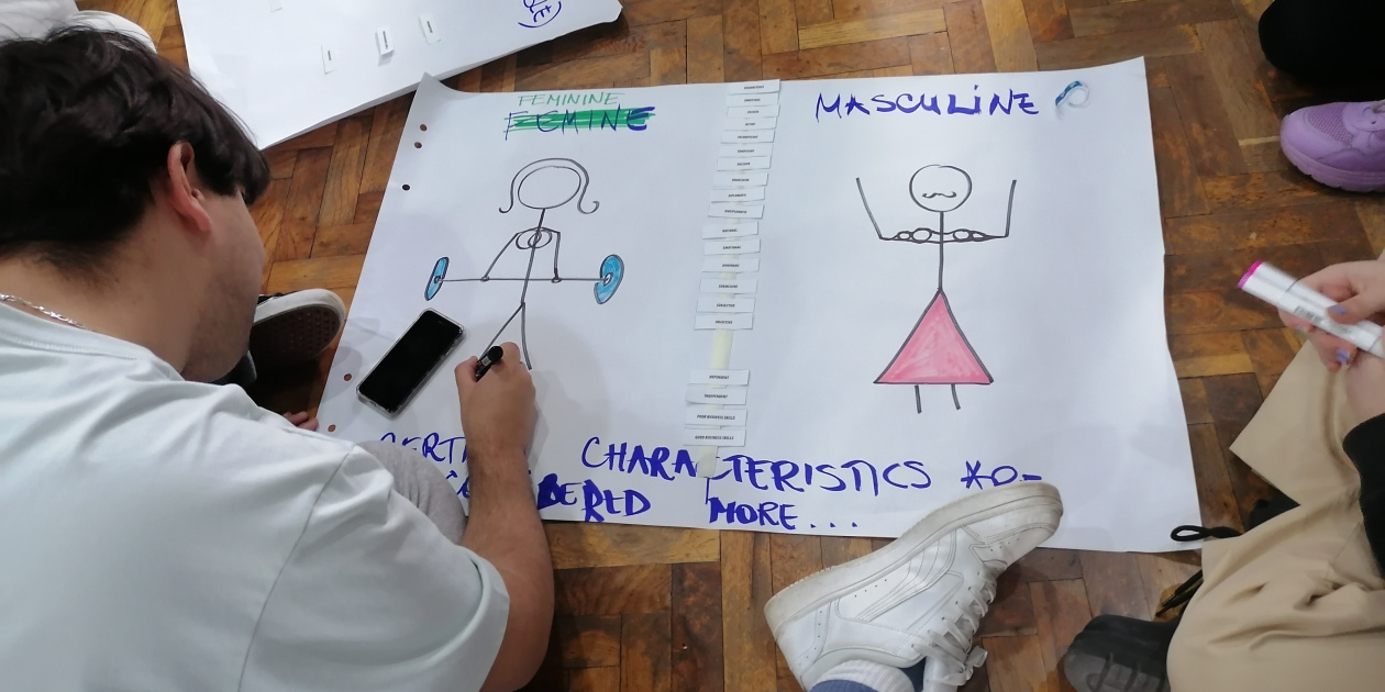 Young guy sit on the floor drawing on a poster