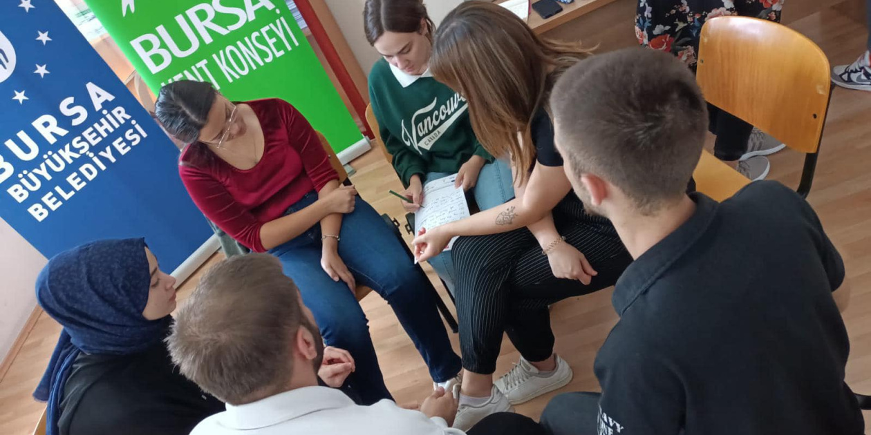 Group of young people brainstorming and taking notes together