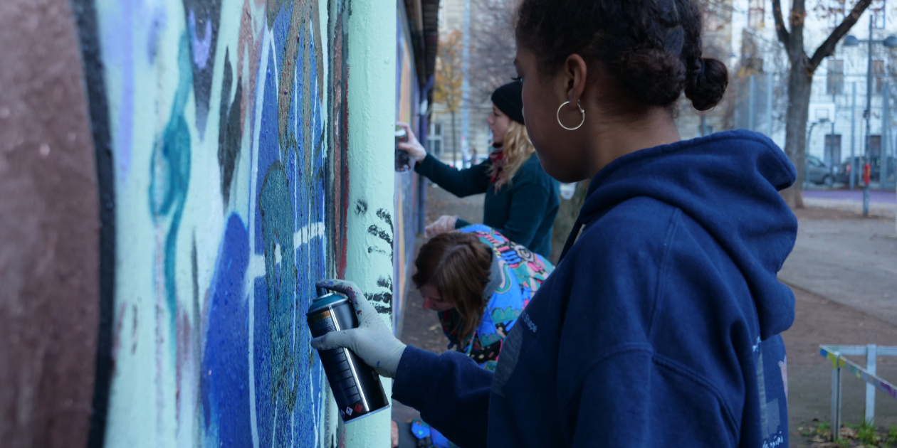 Young girl working painting a wall with spay - copyright: Verein Ronja