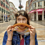 On the photo you can see a dark headed girl holding a churro (pastry) under her nose making a funny face. She is in Spain. 