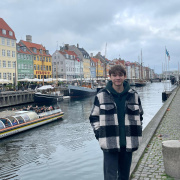 A boy standing on the riverbank. 