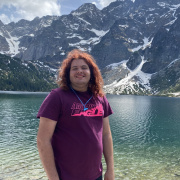 A young person infront of a lake