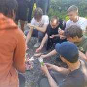 Group of teenagers toasting marshmallows around fire
