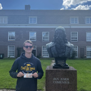 A boy standing next to a statue.