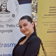 Young girl standing in front of highschool banner 
