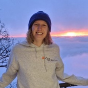 Foto van Julie buiten, met de zonsondergang op de achtergrond.