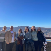 young people standing in front of a mountain