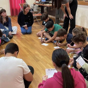 young people are sitting in a circle and writing on a postit