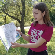 Young DiscoverEU participant Elena reading from a book in nature
